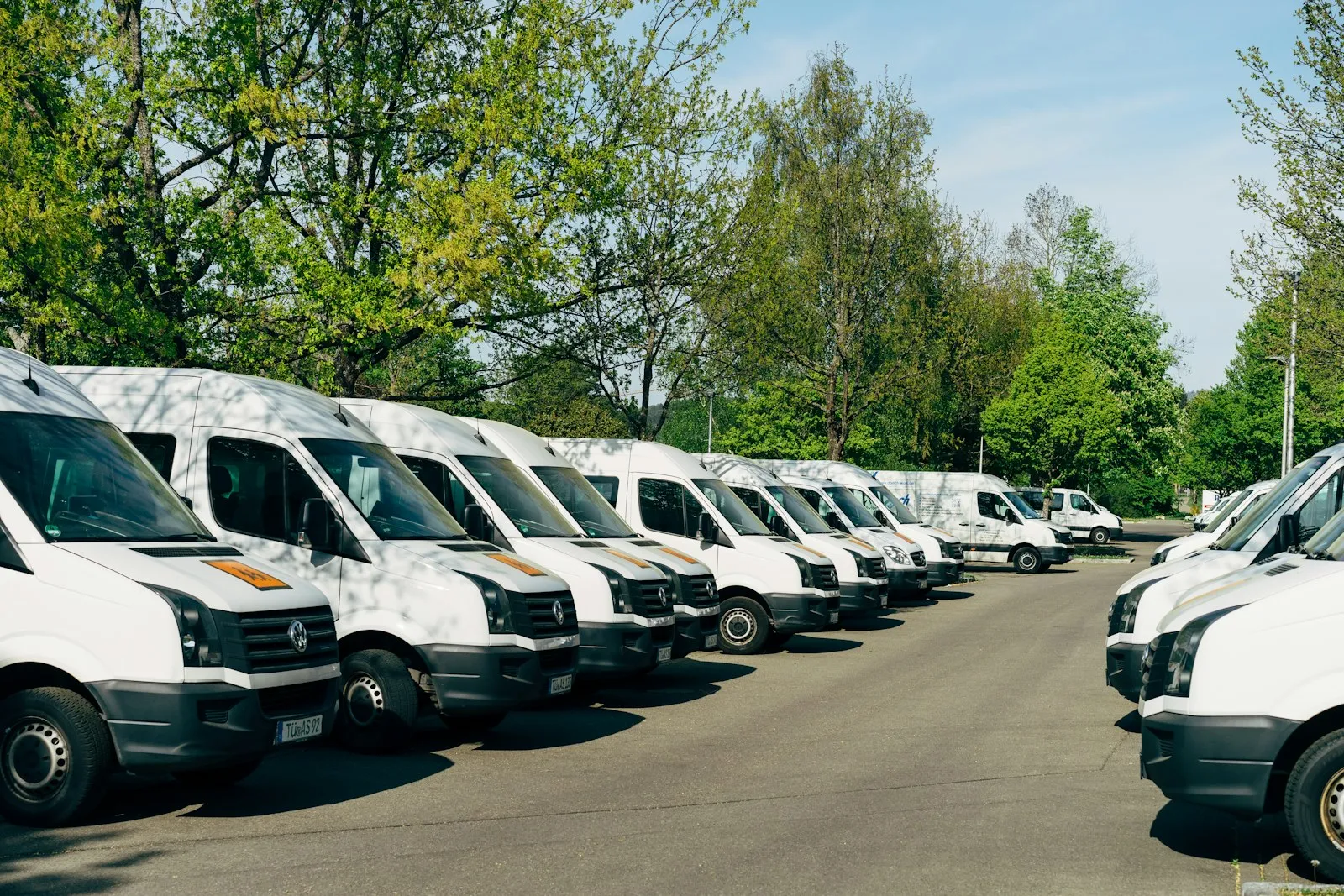 Reihe weißer Transporter auf einem Betriebshof